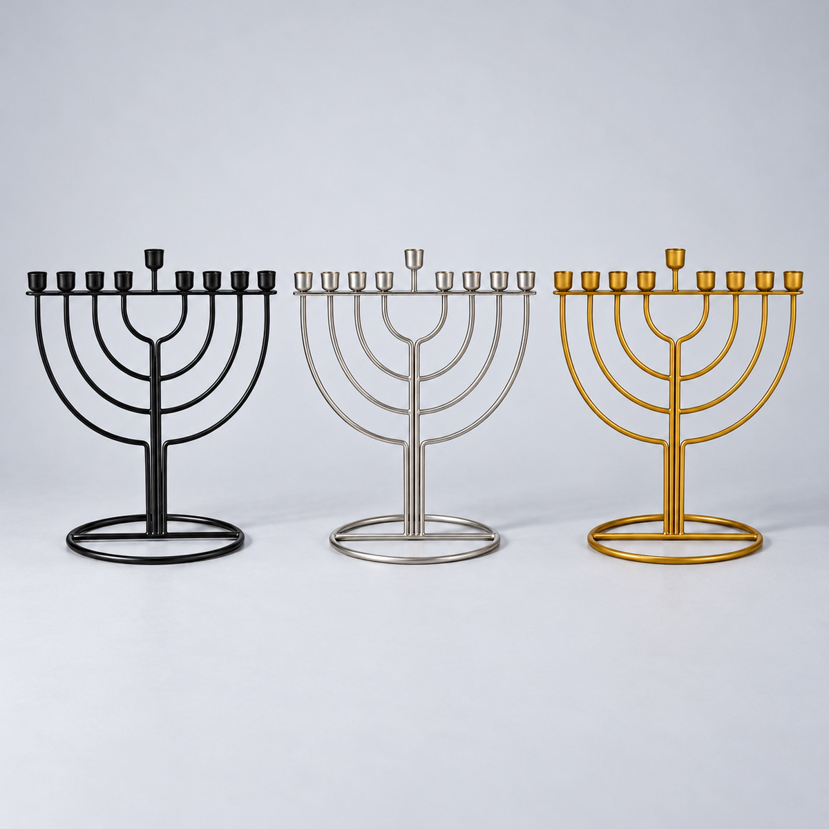 חנוכיית מתכת מעוצבת – שחור, כסף וזהב חנוכיית מתכת מעוצבת בשלושה צבעים – שחור, כסף וזהב, על רקע סטודיו אפור בהיר